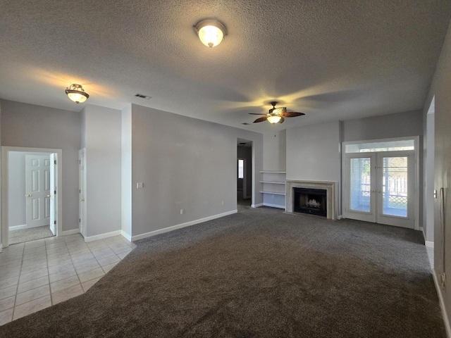 unfurnished living room featuring ceiling fan, light colored carpet, and a textured ceiling