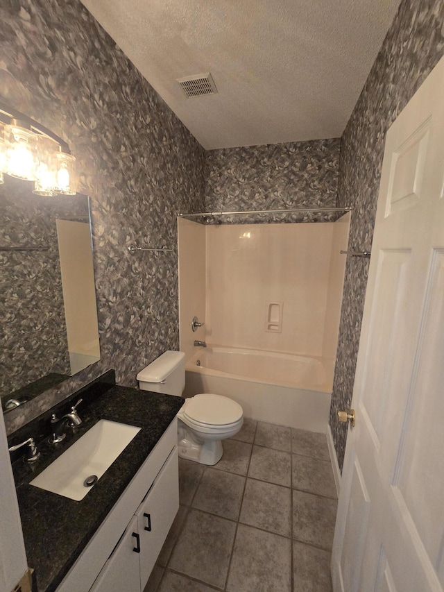 full bathroom featuring bathing tub / shower combination, tile patterned floors, a textured ceiling, toilet, and vanity