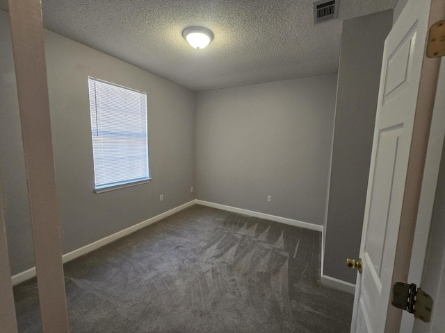 carpeted spare room with a textured ceiling