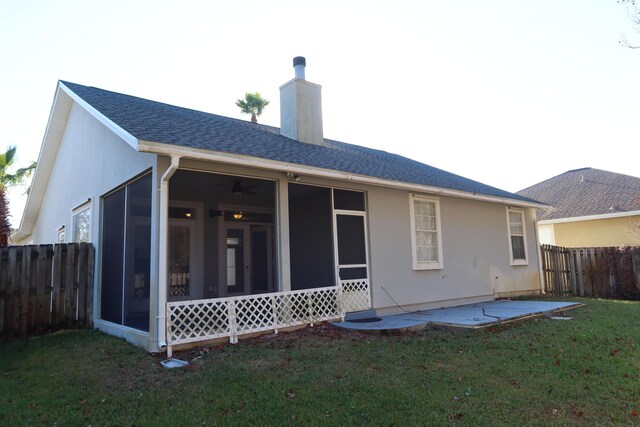 rear view of house with a sunroom, a patio area, and a yard