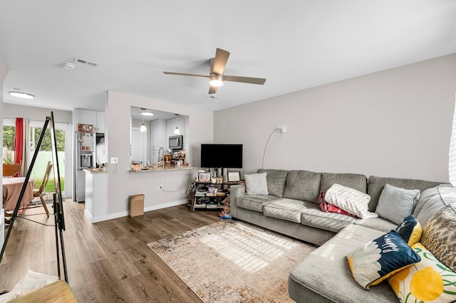 living room with hardwood / wood-style flooring and ceiling fan