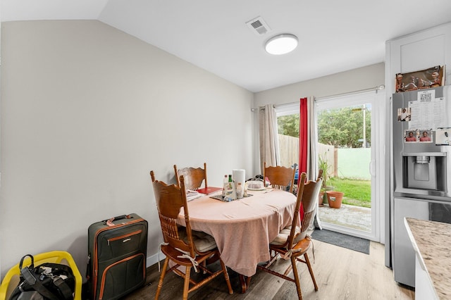 dining area featuring light hardwood / wood-style flooring and vaulted ceiling