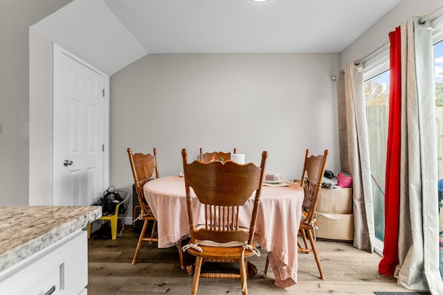 dining space featuring light hardwood / wood-style flooring and lofted ceiling