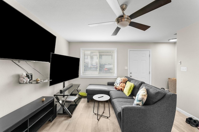 living room featuring ceiling fan and light hardwood / wood-style floors