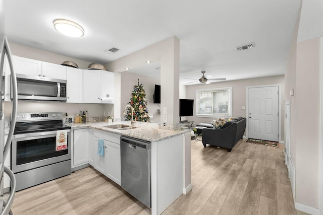 kitchen featuring white cabinets, appliances with stainless steel finishes, kitchen peninsula, and sink