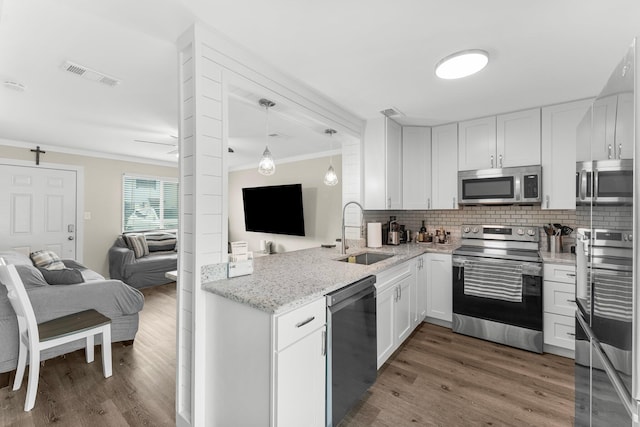 kitchen featuring sink, white cabinetry, stainless steel appliances, and ornamental molding