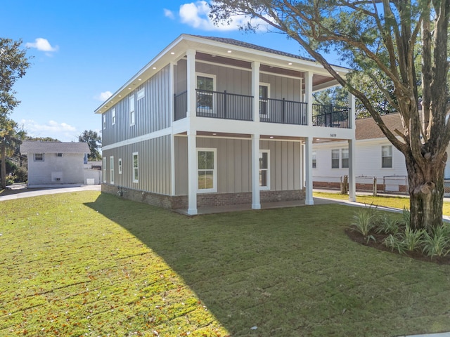 rear view of house with a balcony and a lawn