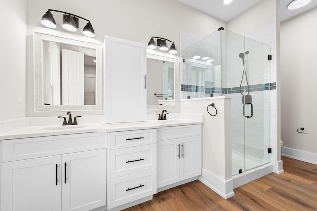 bathroom with wood-type flooring, vanity, and an enclosed shower