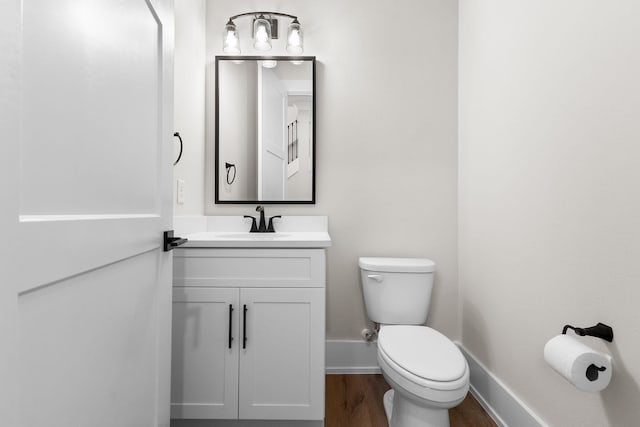 bathroom with vanity, toilet, and wood-type flooring