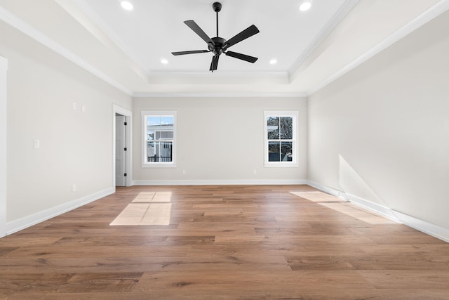 spare room featuring ceiling fan, light hardwood / wood-style floors, a raised ceiling, and crown molding