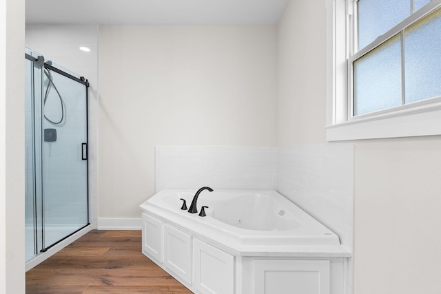 bathroom featuring wood-type flooring and shower with separate bathtub