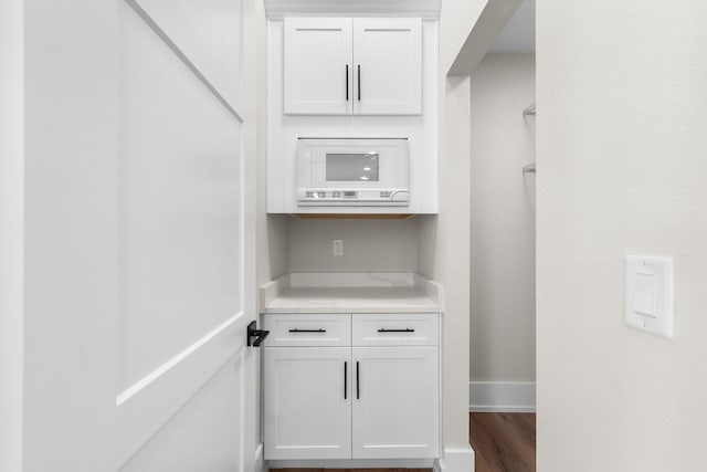 interior space with white cabinetry and dark wood-type flooring