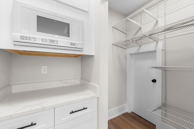 walk in closet featuring a wall unit AC and hardwood / wood-style flooring