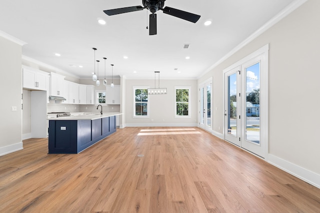 kitchen with pendant lighting, backsplash, white cabinets, crown molding, and sink