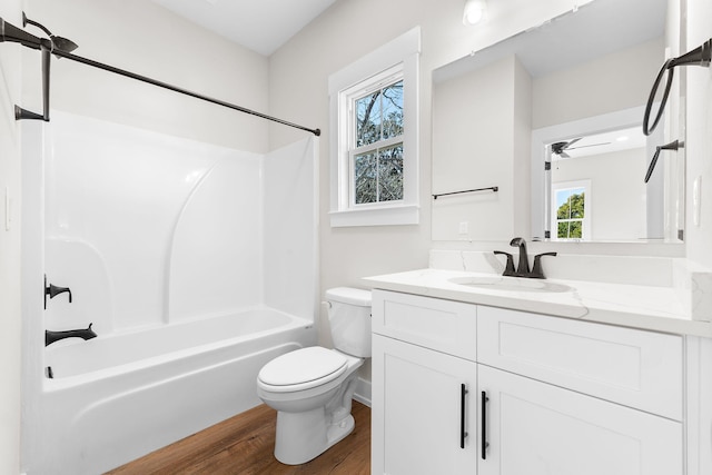 full bathroom with plenty of natural light, wood-type flooring, shower / bathtub combination, and toilet