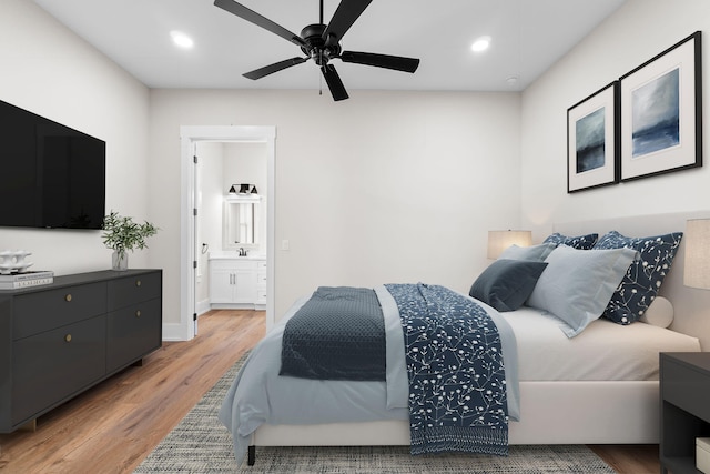 bedroom with light hardwood / wood-style flooring, ensuite bath, ceiling fan, and sink