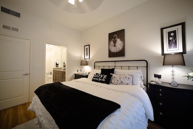 bedroom featuring connected bathroom, ceiling fan, dark hardwood / wood-style flooring, and vaulted ceiling