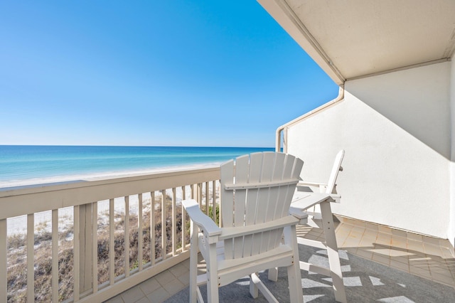 balcony with a water view and a view of the beach