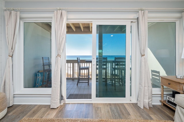 doorway to outside with hardwood / wood-style flooring and a water view