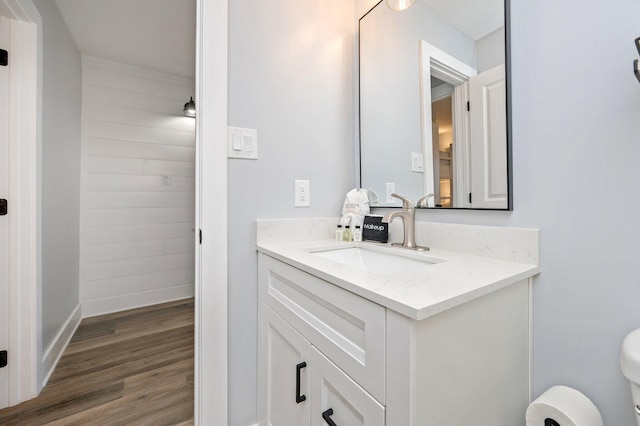 bathroom with hardwood / wood-style flooring, vanity, and toilet