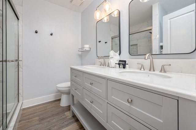 bathroom featuring vanity, wood-type flooring, an enclosed shower, and toilet