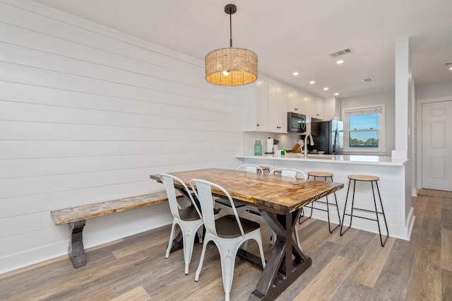 dining room featuring sink and light hardwood / wood-style flooring