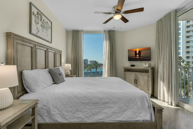 bedroom with access to outside, multiple windows, ceiling fan, and light hardwood / wood-style flooring