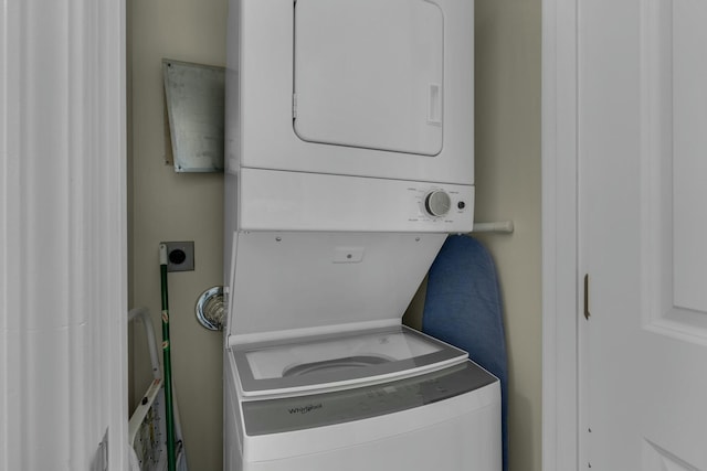 clothes washing area featuring stacked washer and dryer