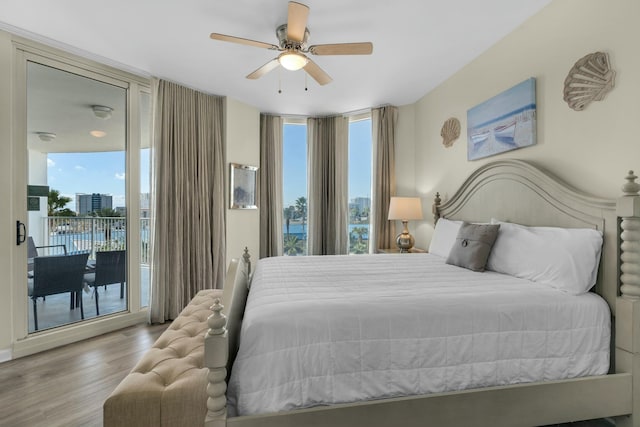 bedroom with access to outside, multiple windows, ceiling fan, and expansive windows