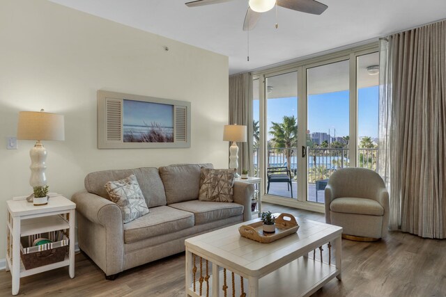 living room with expansive windows, hardwood / wood-style flooring, and ceiling fan