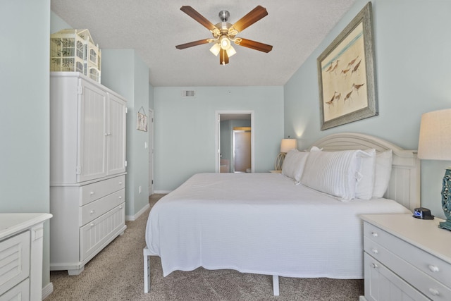 carpeted bedroom with ceiling fan and a textured ceiling