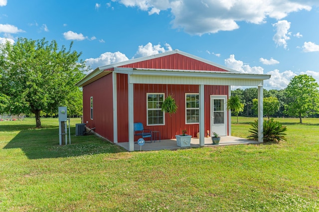 view of outbuilding featuring central AC unit and a yard