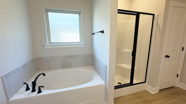 2718 Louis Cir, Crestview, FL 32536 - bathroom featuring a stall shower, a bath, and wood finished floors
