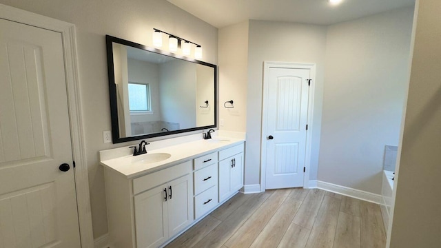 2718 Louis Cir, Crestview, FL 32536 - full bath with a sink, double vanity, a bath, and wood finished floors