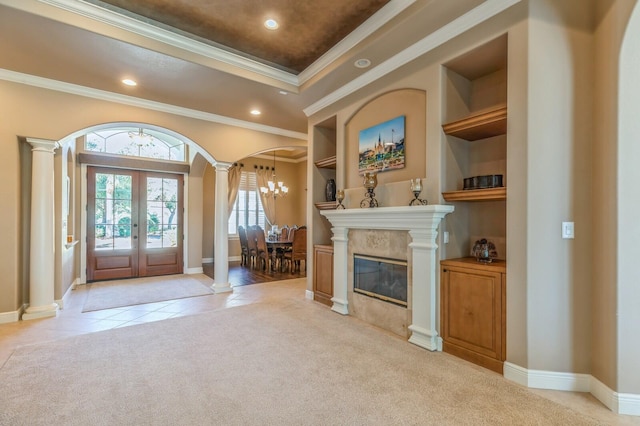 entrance foyer featuring french doors, light colored carpet, an inviting chandelier, and ornamental molding