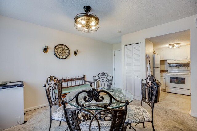 carpeted dining space featuring a textured ceiling