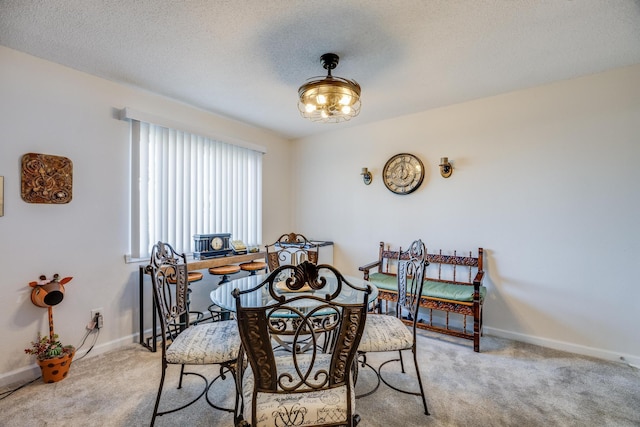 carpeted dining area featuring a textured ceiling