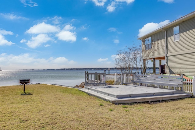 view of dock with a lawn and a deck with water view