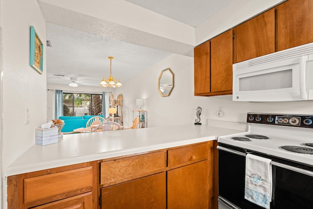 kitchen featuring kitchen peninsula, pendant lighting, a textured ceiling, white appliances, and ceiling fan with notable chandelier