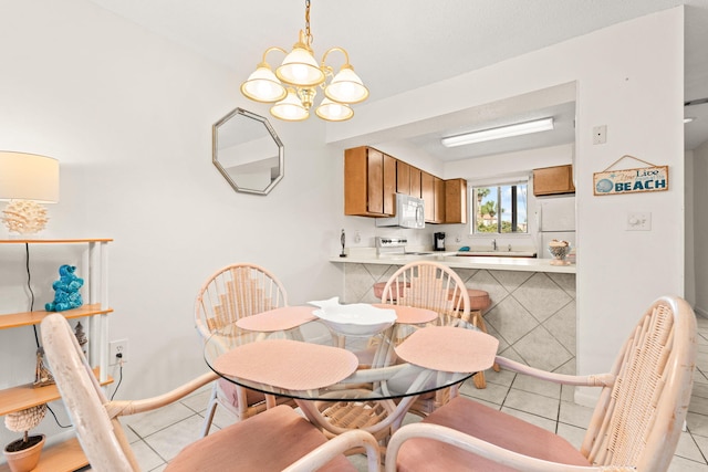 dining space with light tile patterned flooring, sink, and an inviting chandelier