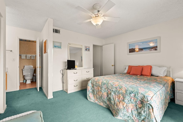 carpeted bedroom featuring ceiling fan, a textured ceiling, and ensuite bath