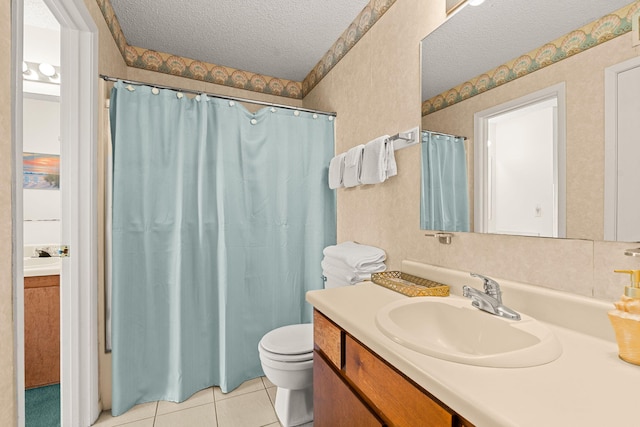 bathroom featuring tile patterned flooring, vanity, a textured ceiling, and toilet