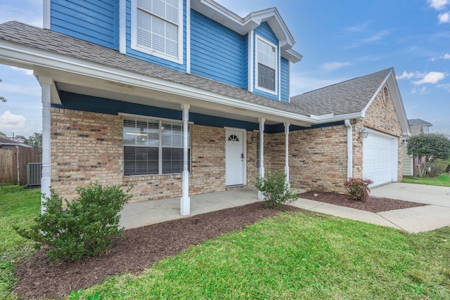 view of front facade featuring a garage, a front yard, and covered porch