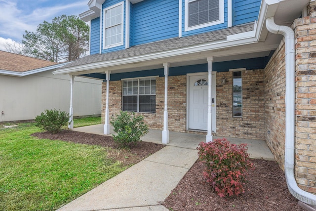 doorway to property featuring a yard and a porch