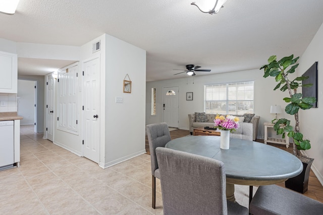 dining room with ceiling fan and a textured ceiling