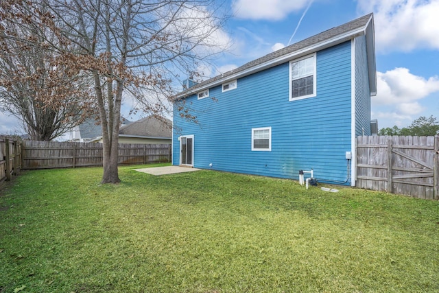 back of house with a yard and a patio