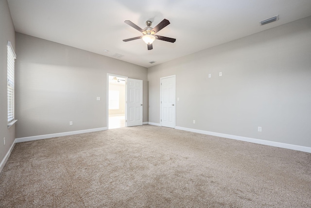 unfurnished room featuring carpet, a wealth of natural light, and ceiling fan