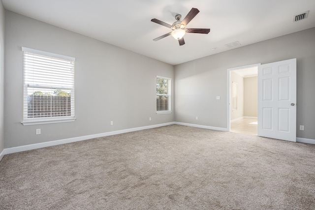 carpeted spare room featuring ceiling fan