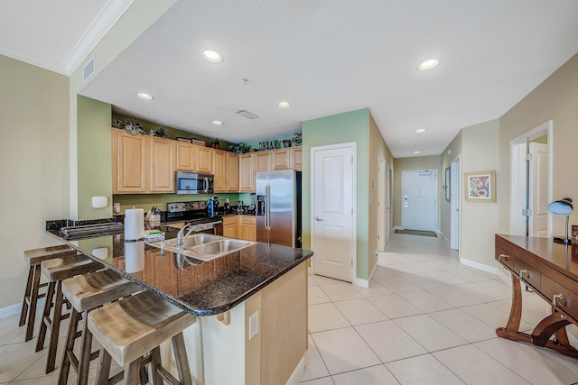 kitchen with a kitchen breakfast bar, sink, light tile patterned floors, appliances with stainless steel finishes, and kitchen peninsula