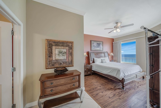 tiled bedroom with ceiling fan, crown molding, and a water view